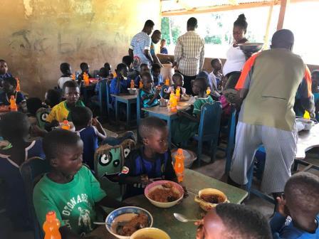 Schoolchildren being served meals in a classroom