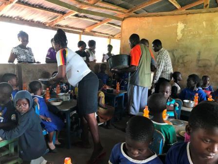 Volunteers serving meals to schoolchildren